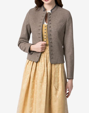 Womens traditional Bavarian trachten jacket in taupe wool, worn over a dirndl dress, featuring a stand collar, long sleeves, and decorative metal button front in classic alpine style.