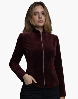 Female model wearing a burgundy velvet jacket with a high collar and front zipper, featuring a fitted tailored silhouette.