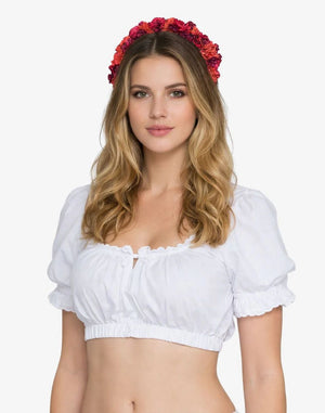 Woman wearing a white top and red floral headband on a white background