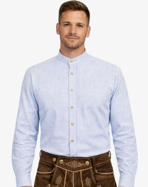 Man wearing a light blue checkered shirt and brown traditional pants on a white background