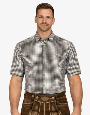 Man wearing a checkered shirt and brown traditional pants on a white background