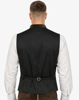 Man wearing a black vest over a white shirt on a white background