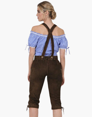 Woman wearing a blue checkered top and brown lederhosen on a white background