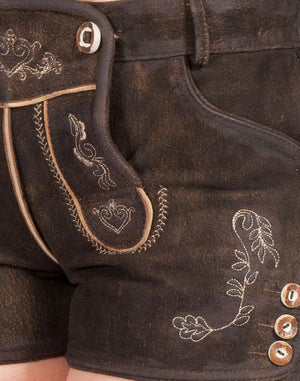 Close-up detail of women’s dark brown leather lederhosen shorts showing traditional embroidered floral patterns, decorative front flap, and side button accents in Bavarian style.