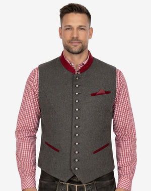 Front view of model wearing Heritage Style Trachten Vest Men in grey wool with red trim collar and metal buttons