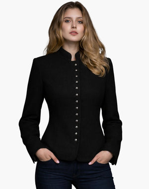 Woman wearing a luxury black Bavarian-style jacket with a high collar, decorative buttons, and a fitted tailored design, paired with dark jeans, against a white background.