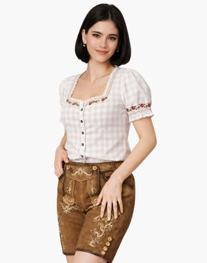 Woman wearing a traditional outfit with a white top and brown pants on a white background