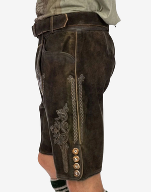 Men Regal Crest Lederhosen side view on model highlighting rustic leather finish, embroidered leg motif, and buttoned hem detail