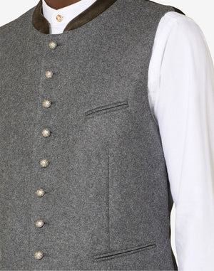 Close up of mens authentic Alpine vest showing decorative metal buttons, wool texture and classic Bavarian craftsmanship.