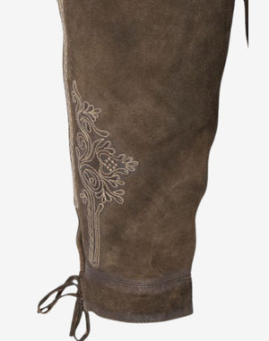 Side view of mens German bundhosen displaying leg embroidery, knee ties and textured brown leather finish inspired by traditional Oktoberfest attire.