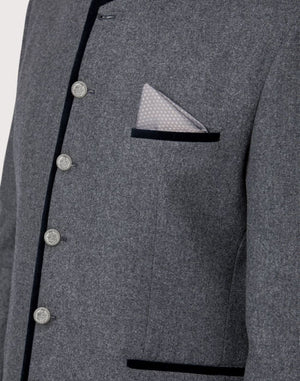 Close up of Trachten jacket chest pocket with patterned pocket square, metal buttons and textured wool fabric.