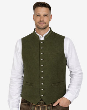 Male model wearing olive green wool Trachten vest paired with traditional lederhosen, ideal for Oktoberfest and Alpine occasions.