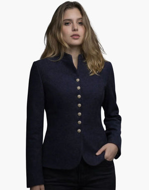 Woman wearing a navy blue blazer with gold buttons on a white background