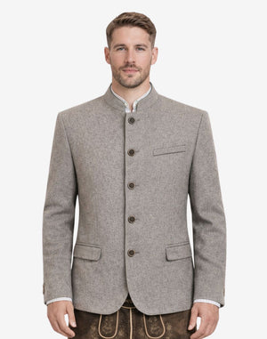 Model wearing rustic grey Bavarian jacket for men with traditional Trachten styling, stand collar, button front closure, tailored fit, and classic Oktoberfest outfit paired with lederhosen.