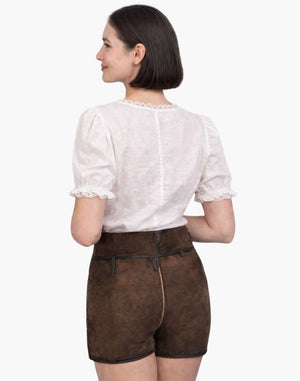 Woman wearing a white blouse and brown shorts on a white background