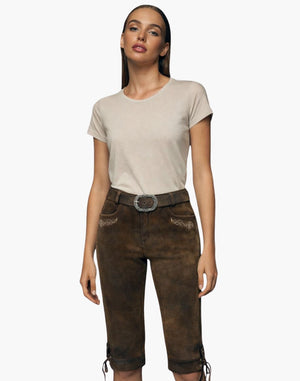 Woman wearing a beige t-shirt and brown pants with a belt on a white background