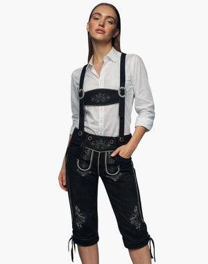 Woman wearing black embroidered Bundhosen with a white shirt on a white background