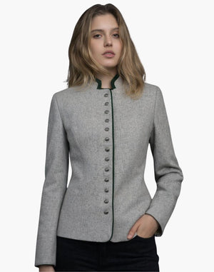Front view of a woman wearing a light gray tailored jacket with a stand-up collar trimmed in dark green. A vertical row of small metallic buttons runs down the front, and the fitted silhouette is styled with dark jeans. The background is plain light gray.