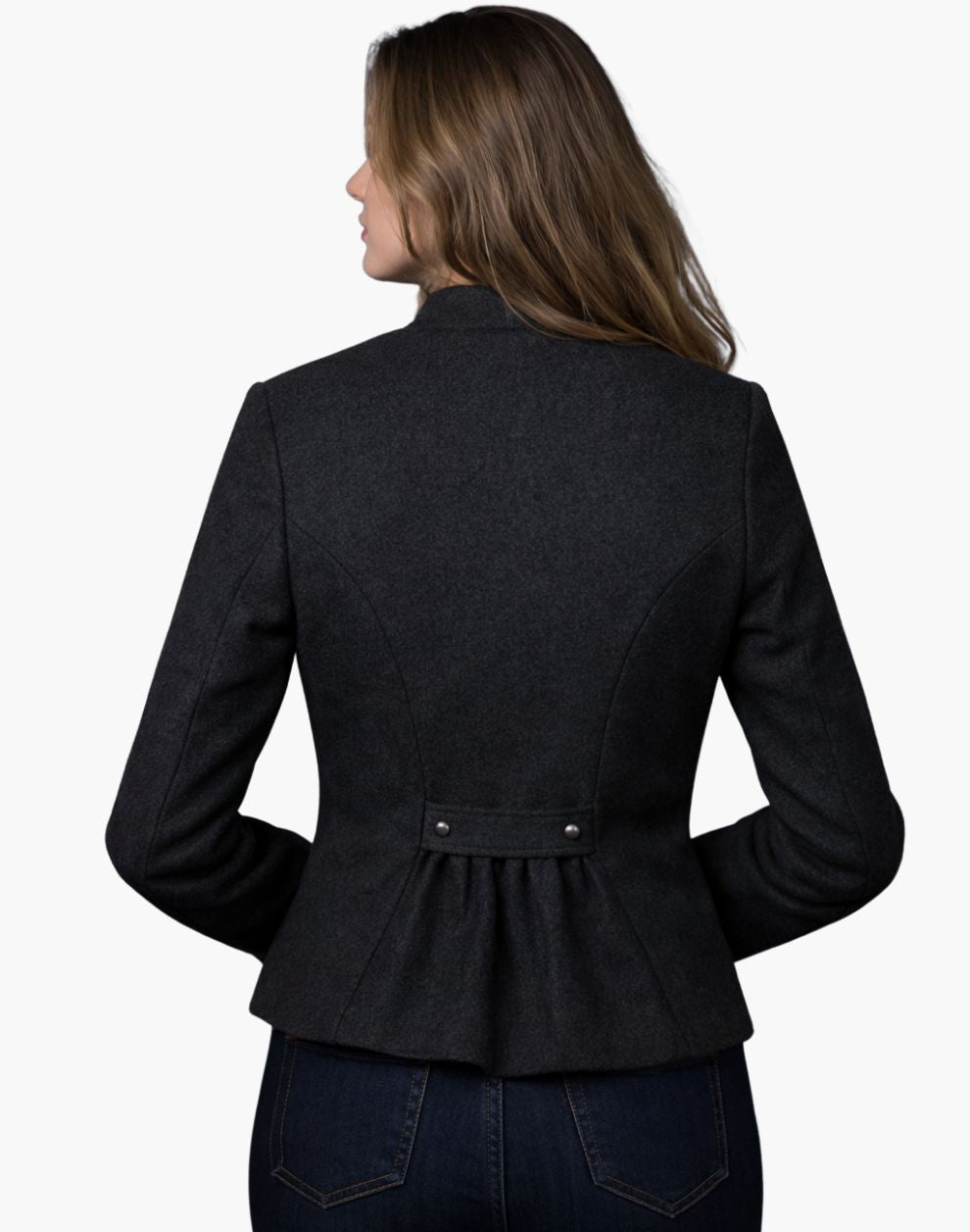 Back view of a woman wearing a charcoal grey tailored Trachten jacket with a fitted waist and pleated back detail, paired with dark jeans, against a white background.