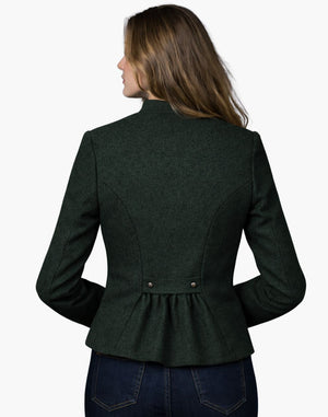 Back view of a woman wearing a dark green tailored Trachten jacket with a fitted waist and pleated back detail, paired with dark jeans, against a white background.