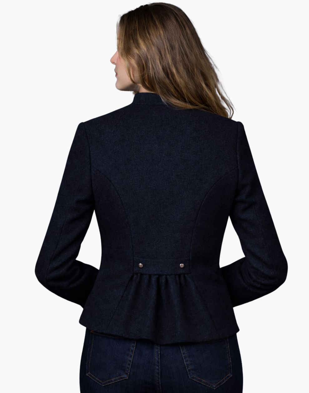 Back view of a woman wearing a navy blue Trachten-style jacket with a fitted waist and pleated back detail, paired with dark jeans, against a white background.