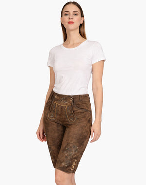 Woman wearing brown traditional pants with a white top on a white background