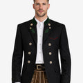Model wearing alpine black wool men’s Trachten jacket with green collar accents, decorative buttons, and traditional Bavarian design paired with lederhosen.
