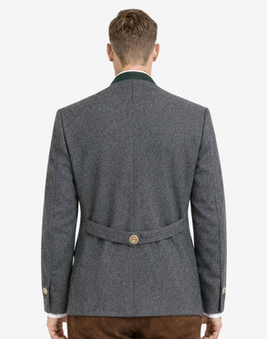 Back view of alpine dark gray wool men’s Trachten jacket on model, featuring traditional Bavarian tailoring, structured fit, and decorative back belt detail.