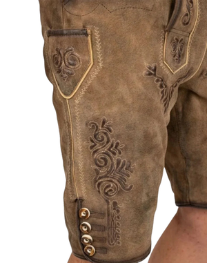 Detail close: Close up on Authentic Alpine Lederhosen Men showing flap pocket stitching and embossed scrollwork near buttons