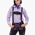 Person wearing a traditional Bavarian outfit with a purple checkered shirt, black lederhosen, and suspenders on a white background.