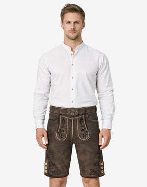Model wearing authentic German lederhosen for men in brown leather with traditional Bavarian embroidery