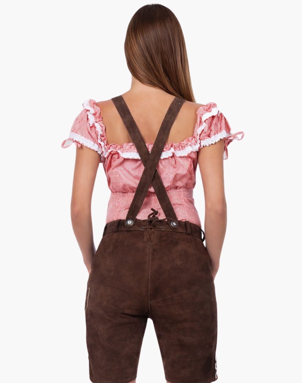 Woman wearing a pink blouse with ruffles and brown suspenders on a white background