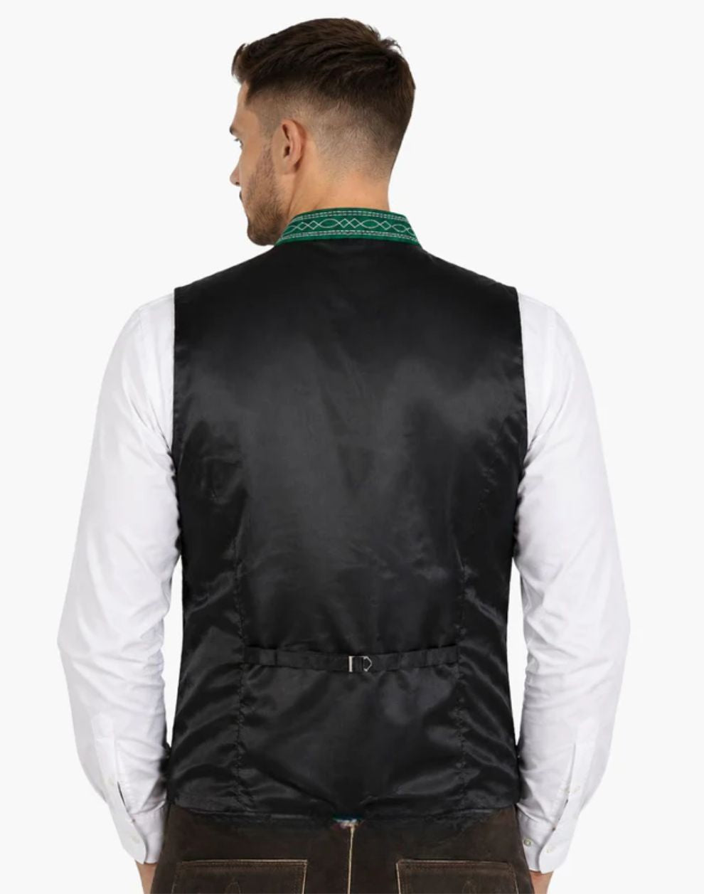 Back view of a men's black Trachten vest with an adjustable back buckle, green embroidered standing collar, and white shirt, paired with brown Lederhosen. Ideal for Oktoberfest and traditional Bavarian attire.
