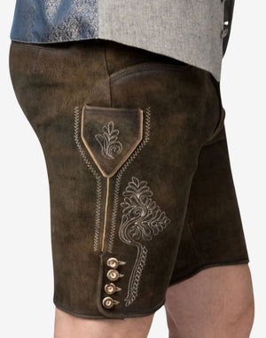Traditional brown Bavarian lederhosen made from suede leather with embroidered detailing, side buttons, and a decorative belt buckle.