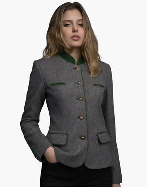 Female model wearing a grey Bavarian Trachten jacket with green collar trim, decorative buttons, and a fitted alpine-style silhouette.