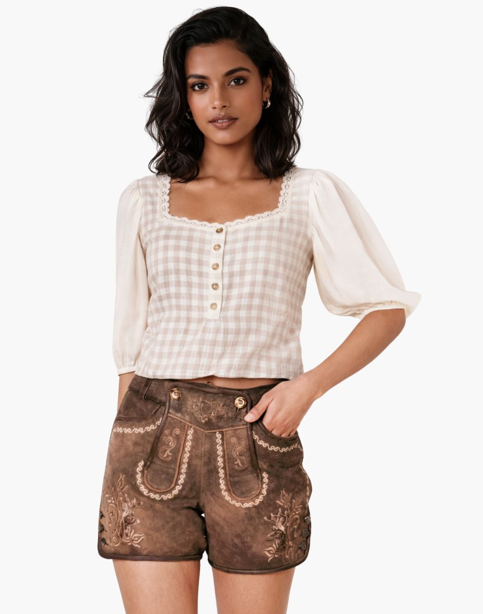 Woman wearing a white blouse with ruffled sleeves and brown embroidered shorts on a white background