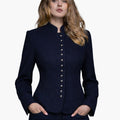 Woman wearing a navy blue Bavarian-style Trachten jacket with decorative buttons, high collar, and a fitted tailored design, paired with dark jeans, against a white background.
