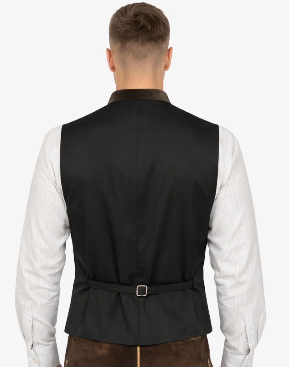 Man wearing a black vest over a white shirt on a white background