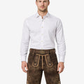 Model wearing classic alpine lederhosen for men in brown leather with traditional Bavarian embroidery and belt buckle