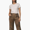 Woman wearing a white t-shirt and brown distressed pants on a white background