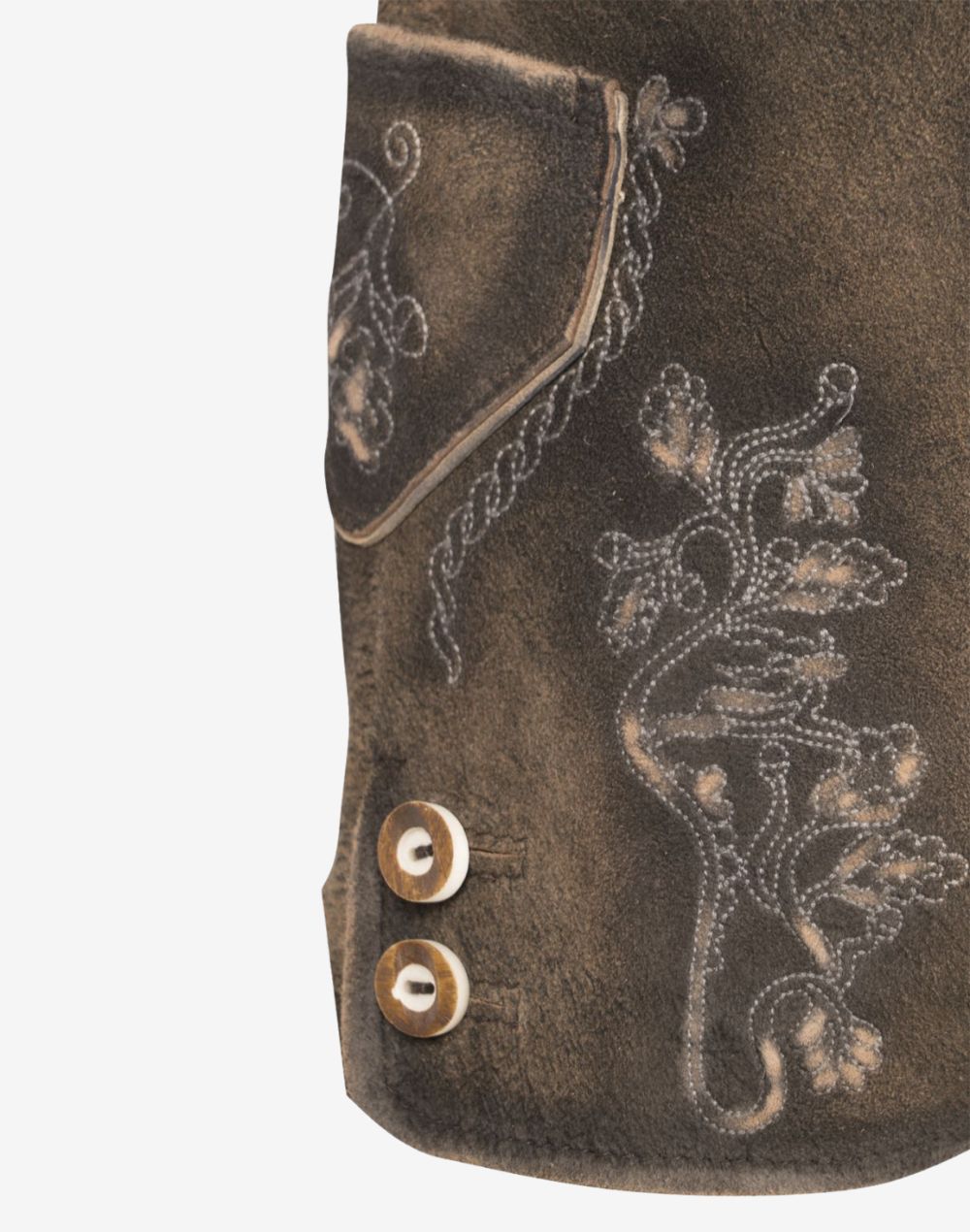 Close-up of brown leather women’s lederhosen showing embroidered floral detailing near the side pocket and decorative side buttons on a distressed leather finish.