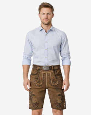 Model wearing classic German lederhosen for men in brown leather with embroidered Bavarian details and traditional Oktoberfest belt