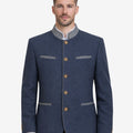 Model wearing classic navy blue Trachten jacket with traditional Bavarian details, paired with lederhosen for authentic Oktoberfest outfit and heritage styling.
