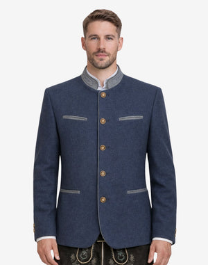 Model wearing classic navy blue Trachten jacket with traditional Bavarian details, paired with lederhosen for authentic Oktoberfest outfit and heritage styling.