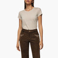 Woman wearing a beige t-shirt and brown bundhosen on a white background