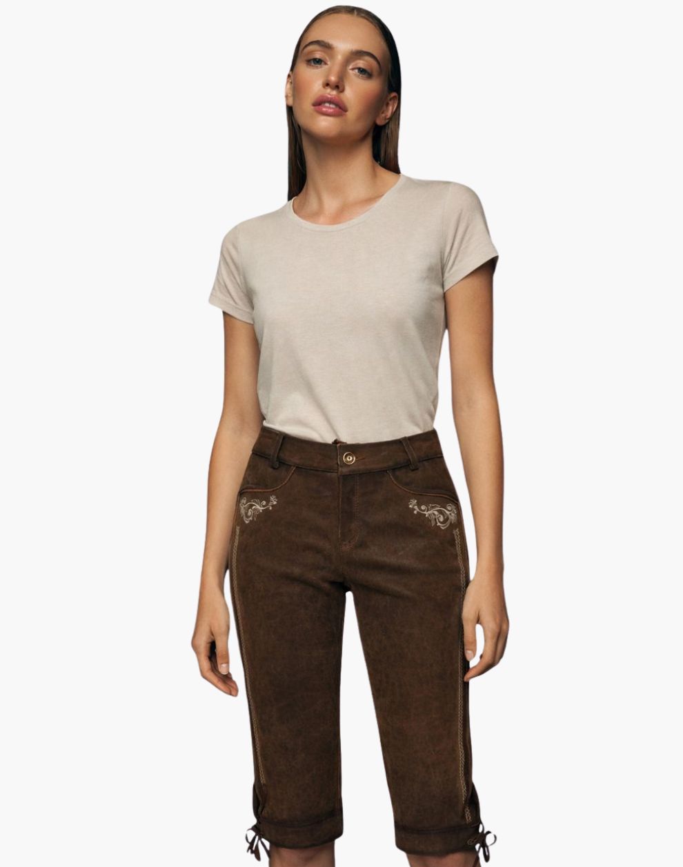 Woman wearing a beige t-shirt and brown bundhosen on a white background