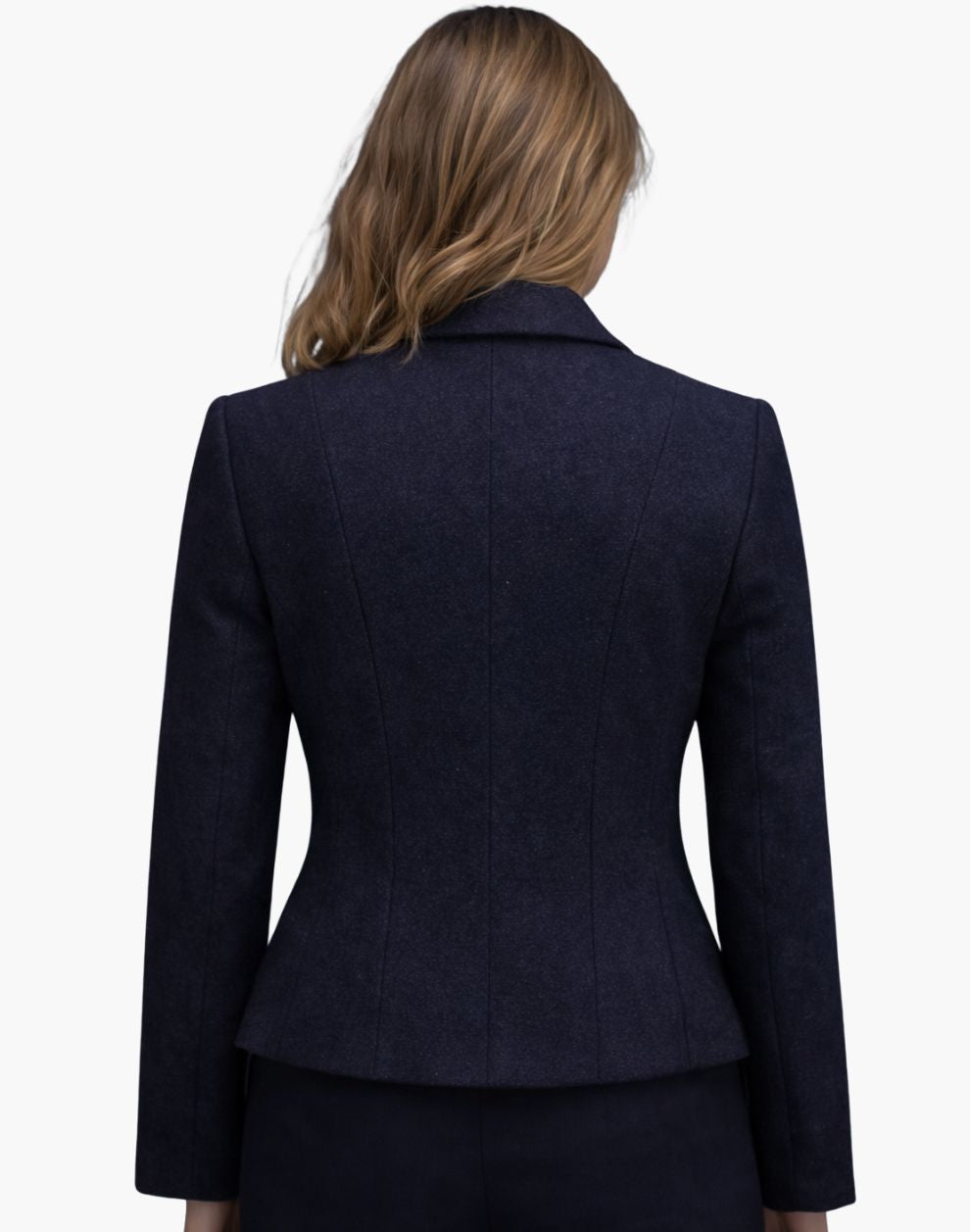 Back view of a woman wearing a fitted deep navy wool jacket with structured vertical seams that contour the waist and a slightly flared hem. The tailored jacket is paired with dark trousers, and her shoulder-length blonde hair falls naturally over the collar. The background is plain light gray in a studio setting.