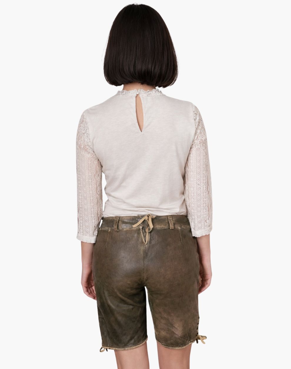 Person wearing a white lace top and brown leather shorts on a white background