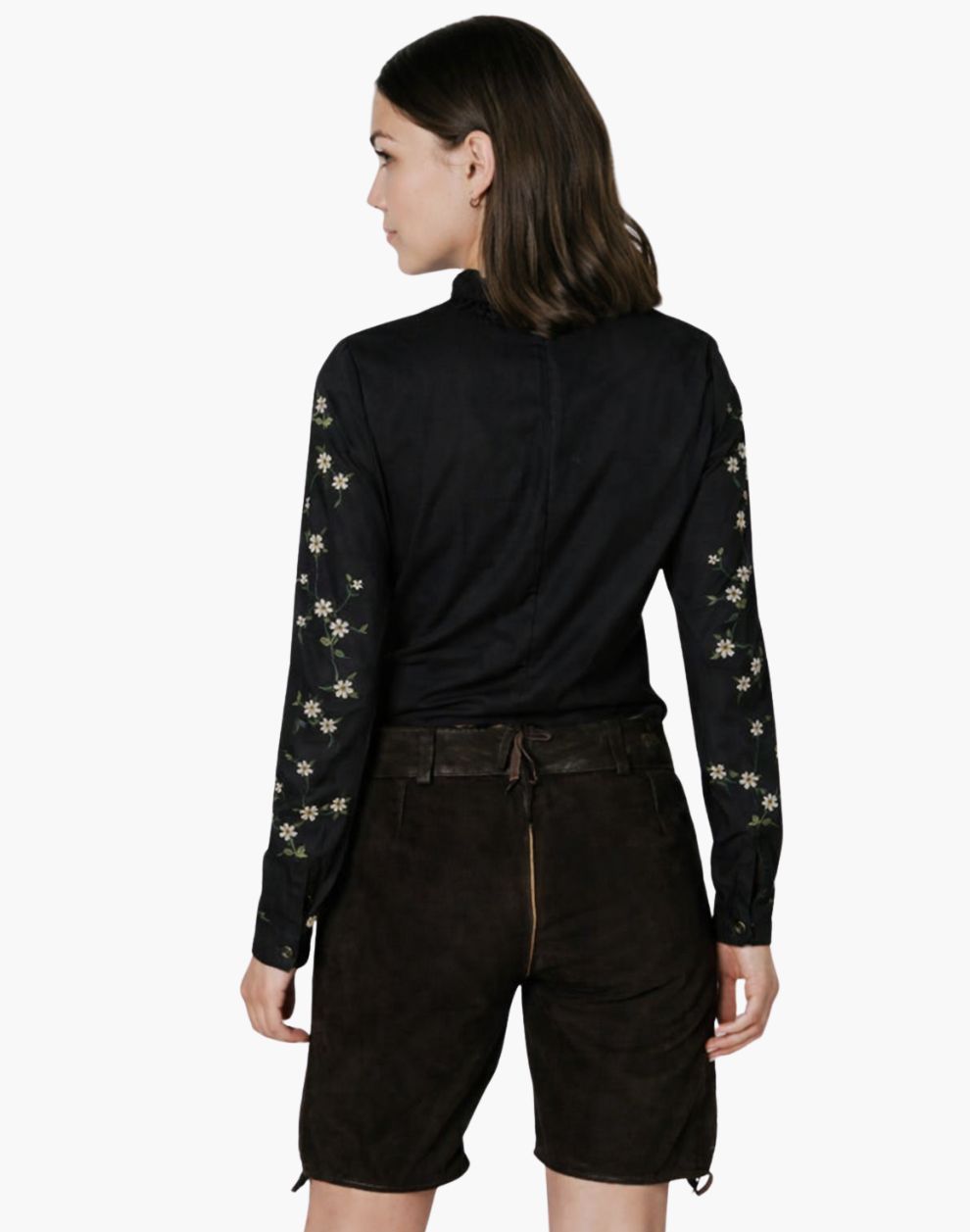 Woman wearing a black long-sleeve top with floral patterns and black shorts on a white background