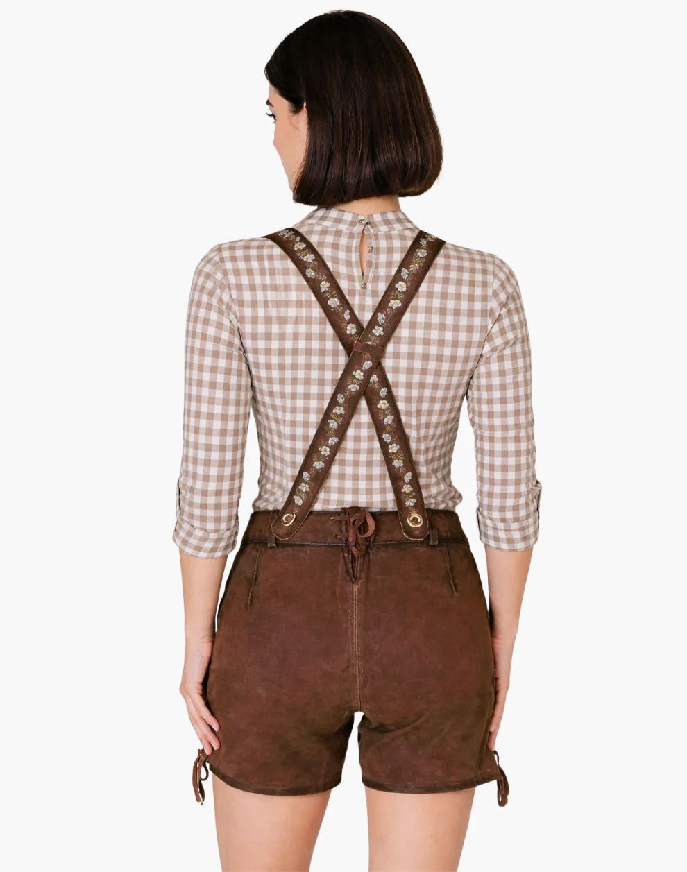 Person wearing a checkered shirt and brown leather suspenders with shorts on a white background